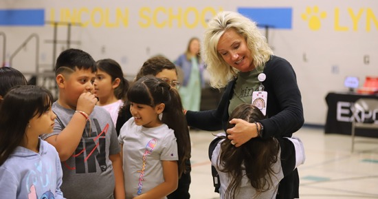 Kristin Schutlz hugging Lincoln Elementary students at the awards ceremony.